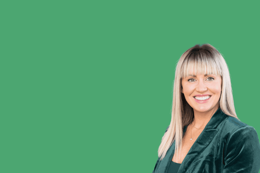 Professional headshot of Emilee Cronin wearing a dark green blazer.